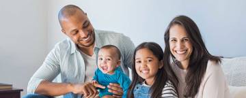 Diverse Family Sitting On Sofa